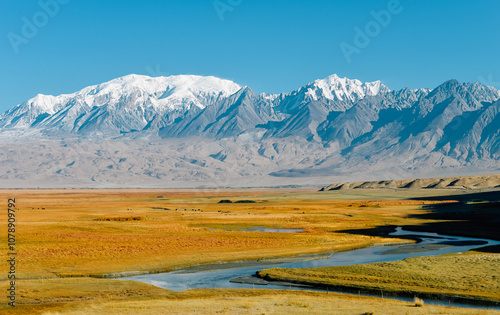 The beautiful autumn scenery of the Taheman Wetland and snow-capped mountains on the Pamir Plateau in Xinjiang, China. photo