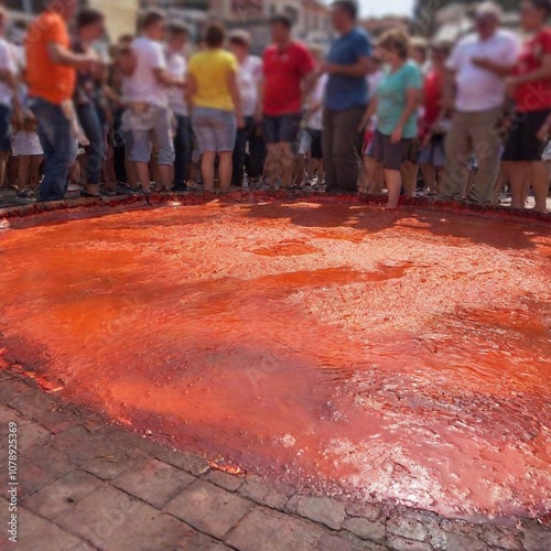 Create a full shot of participants in La Tomatina from a ground-level perspective, using deep focus to capture the entire scene with sharp details from the foreground to the background, showcasing the photo