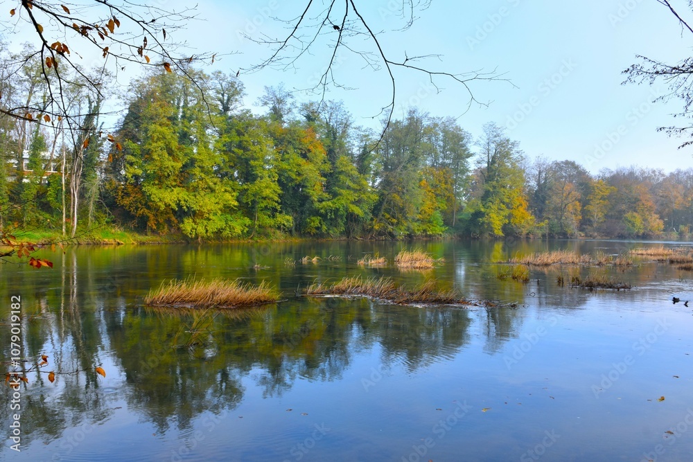 Krka river at Otočec in Dolenjska, Slovenia with autumn colored trees on the shore Krka river at Otočec in Dolenjska, Slovenia with autumn colored trees on the shore