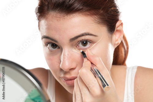 Woman  applying concealer on flawless fresh skin, doing make up. Girl  put corrector under eye area.