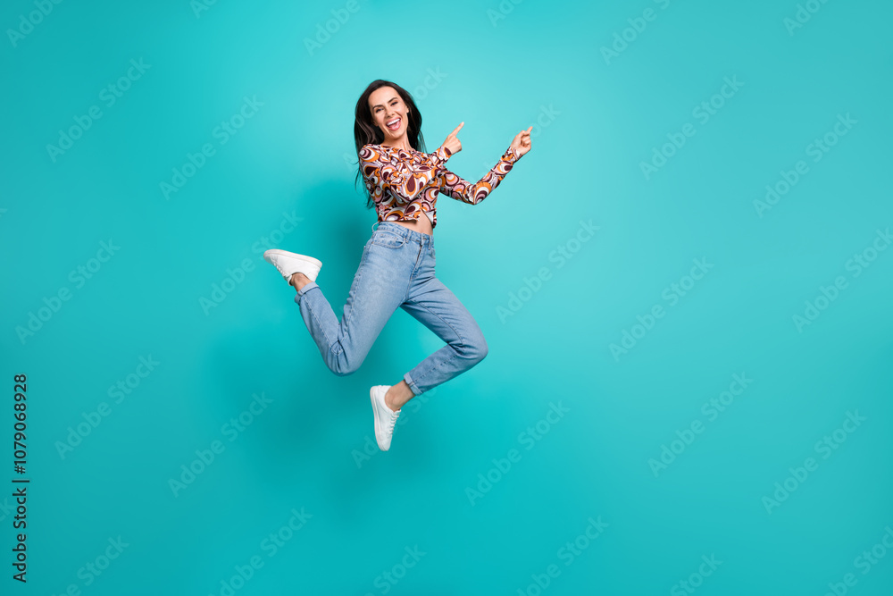 Full length photo of shiny attractive lady dressed retro shirt jumping high pointing empty space isolated blue color background