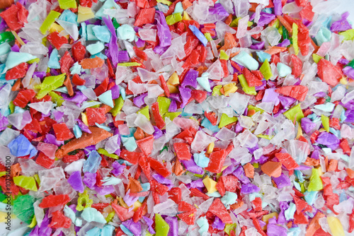 Foto Various colored plastic waste shreds mixed on a white background, ready for the recycling process