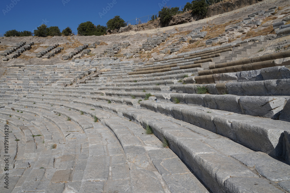 The ancient theatre, also known as the amphitheater of Halicarnassus, showcases the Greco-Roman architectural style in Bodrum, Turkey. It features a cutaway view of the cavea, or the seating area. The ancient theatre, also known as the amphitheater of Halicarnassus, showcases the Greco-Roman architectural style in Bodrum, Turkey. It features a cutaway view of the cavea, or the seating area.