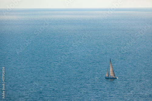 Regatta sailing ship yachts with white sails at opened sea. Aerial view of sailboat in windy condition. photo