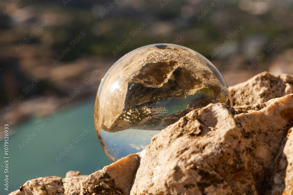 Obraz premium Crystal glass ball sphere reveals nature landscape with macro view