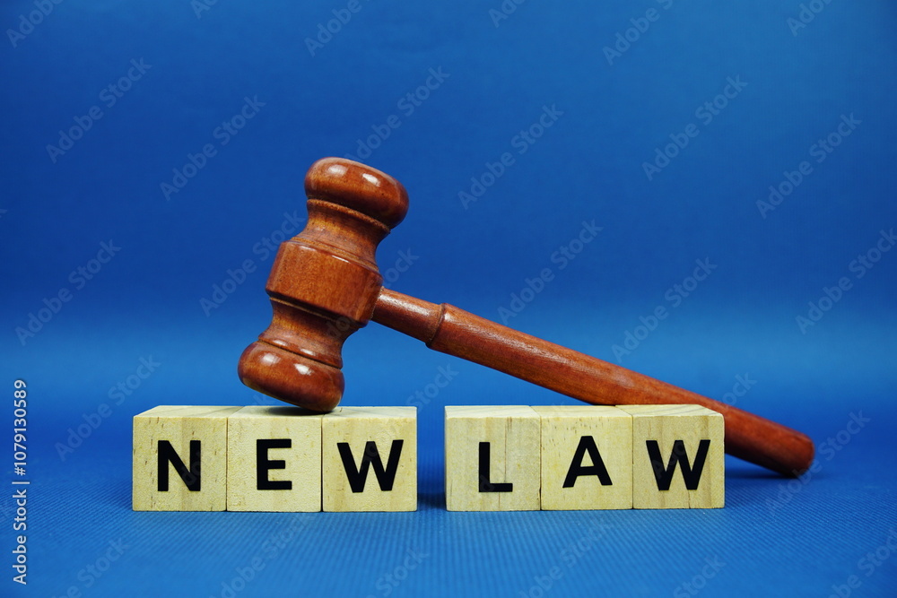 New Law alphabet letters with wooden blocks alphabet letters and Gavel on blue background New Law alphabet letters with wooden blocks alphabet letters and Gavel on blue background