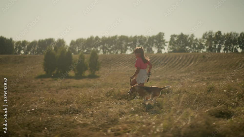 Young girl runs joyfully with her dog on a leash through open farmland, capturing carefree childhood, strong bond with pet, and love for outdoor adventure Young girl runs joyfully with her dog on a leash through open farmland, capturing carefree childhood, strong bond with pet, and love for outdoor adventure