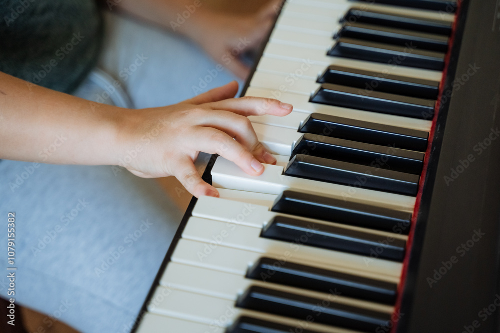 Obraz premium A person is playing a piano with their hand on the keys