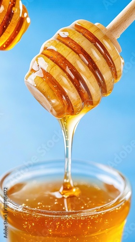  A close-up of a honey dip in a glass with a wooden dipper and a blue sky background