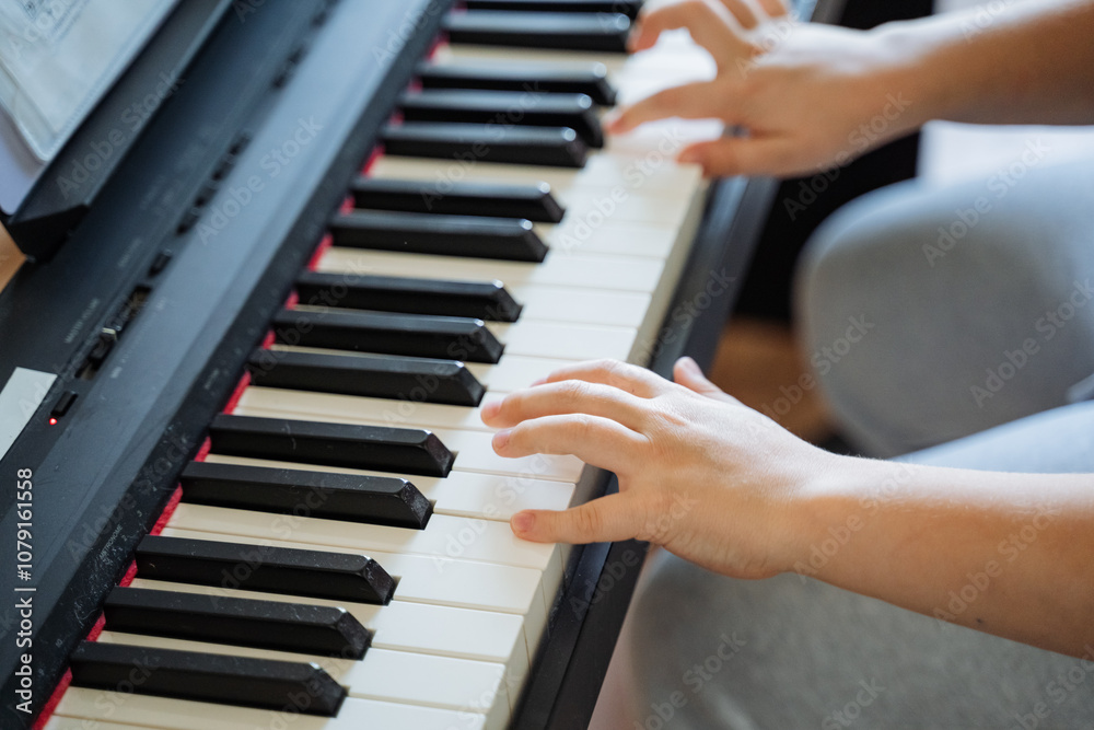 Fototapeta premium A highly skilled and talented pianist expertly plays a beautiful grand piano, producing a soothing and mesmerizing melody that captivates and enchants all who listen with great attention