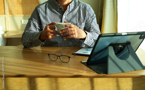 An executive level business man is holding a coffee mug, and re-checking the data analyst, graph analytics diagram work paper for best solution to explaining Business feasibility increase sales profit photo