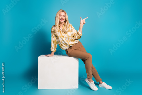 Full length photo of stunning mature lady cube point empty space dressed stylish formalwear clothes isolated on cyan color background photo