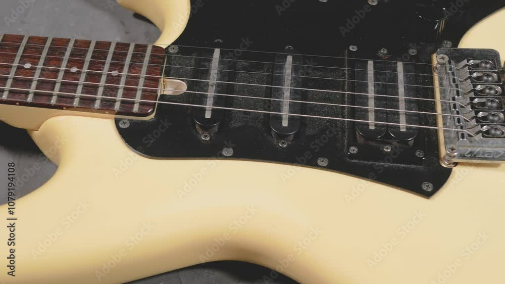 Yellow electric guitar with three pickups lies on a dark background. Close-up. Yellow electric guitar with three pickups lies on a dark background. Close-up.