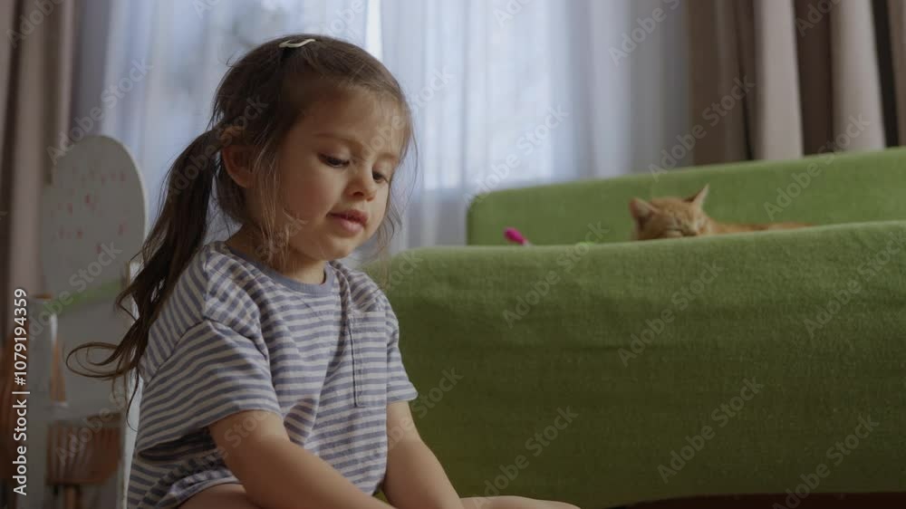 A child joyfully playing with various colorful objects in a cozy home environment