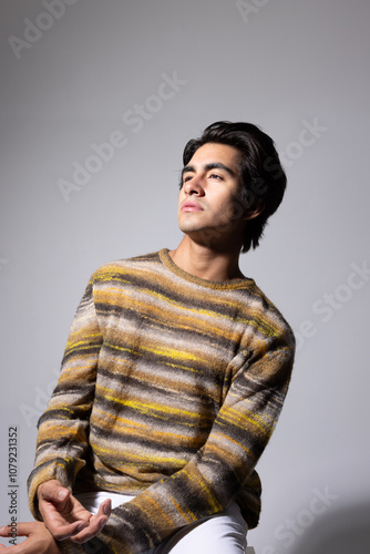 Young man with dark hair posing over white background. Vertical.