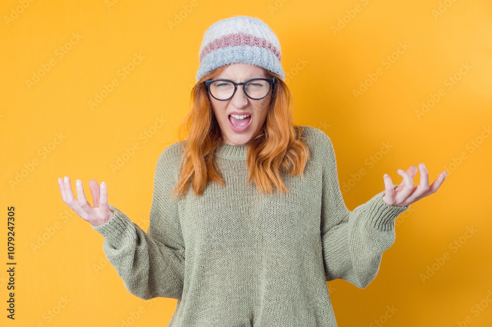Furious girl looking at camera and shows hands, isolated on yellow background. Rage young woman