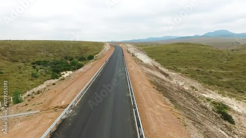 Recorrido aéreo de un camino en carretera en un paisaje árido con poca vegetación  photo