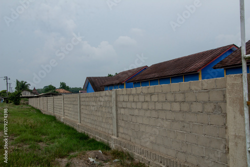 school wall fence with cement or brick finishing outdoors with sky blue photo