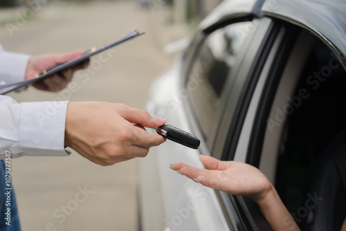 Obraz na plátně Car Key Handoff: A close-up shot of a car key being exchanged between two people, symbolizing a moment of transaction and new beginnings
