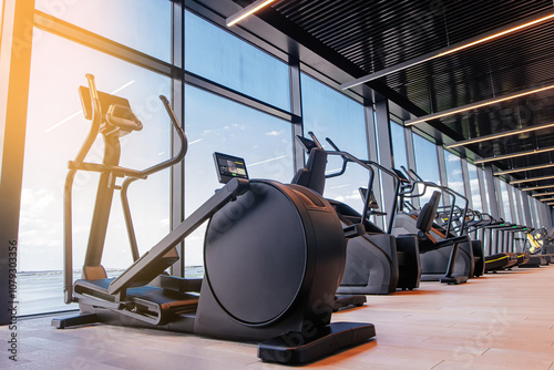 Modern light gym. Sports equipment in gym. Elliptical trainer