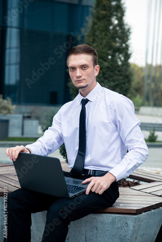 Caucasian man with laptop, manager on city center background. Freelancer