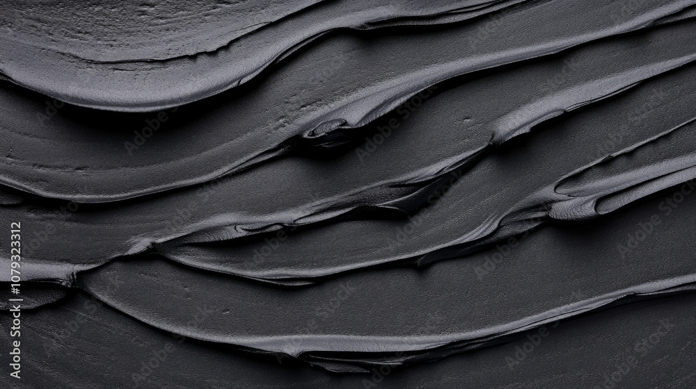 Fototapeta premium Thick black texture spread on a surface, showcasing smooth layers and depth