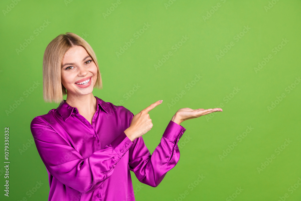 Photo of cheerful stunning girl wear stylish pink clothes hold empty space isolated on green color background Photo of cheerful stunning girl wear stylish pink clothes hold empty space isolated on green color background