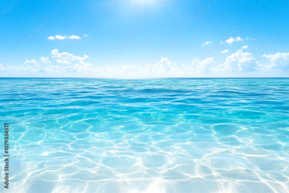 Obraz premium Luminous turquoise ocean water under bright blue sky with soft clouds