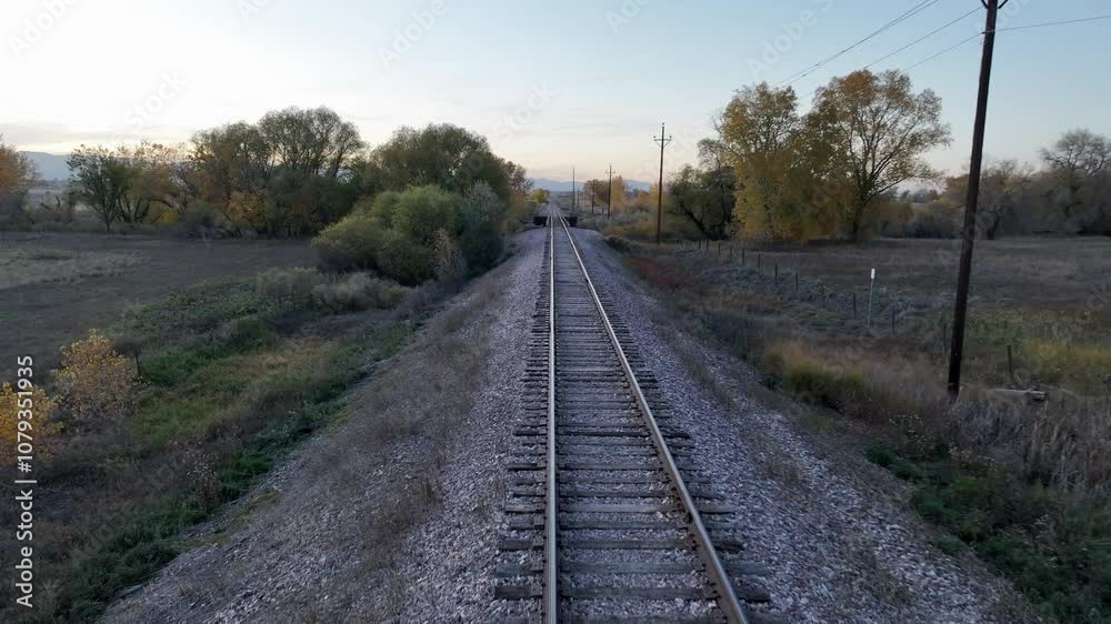 flying over single railroad track, fall scenery at dusk in northern Colorado flying over single railroad track, fall scenery at dusk in northern Colorado