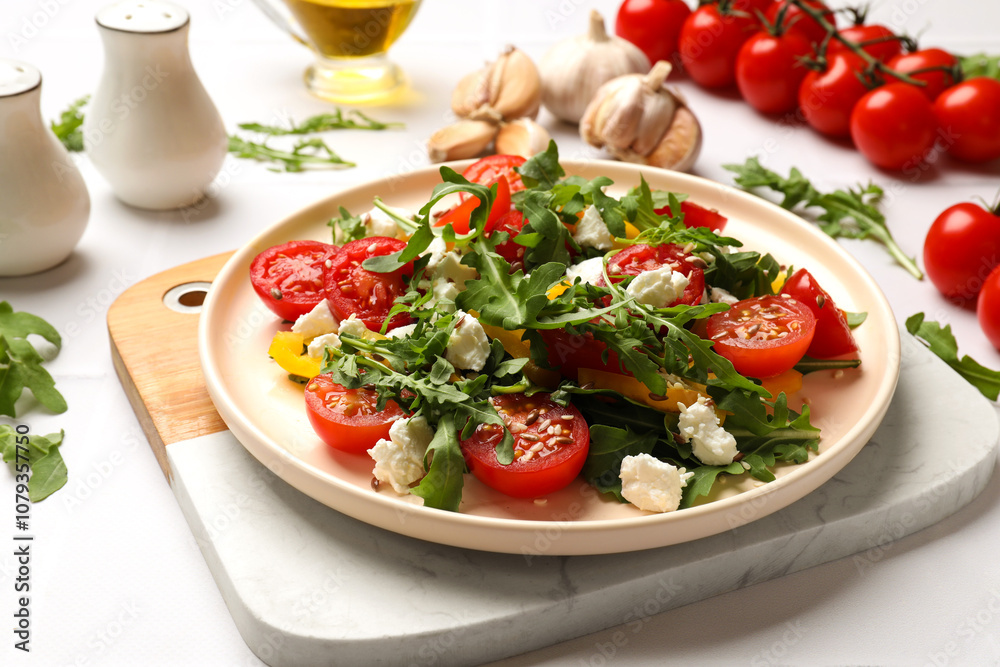 Tasty salad with arugula, cheese and vegetables on white table, closeup Tasty salad with arugula, cheese and vegetables on white table, closeup