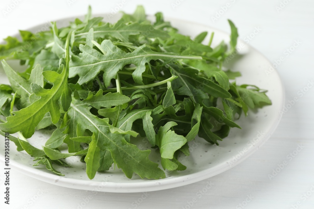 Fresh green arugula leaves on white table, closeup Fresh green arugula leaves on white table, closeup