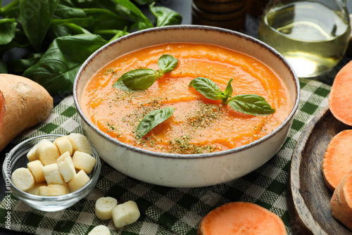 Delicious sweet potato soup in bowl served on grey table, closeup