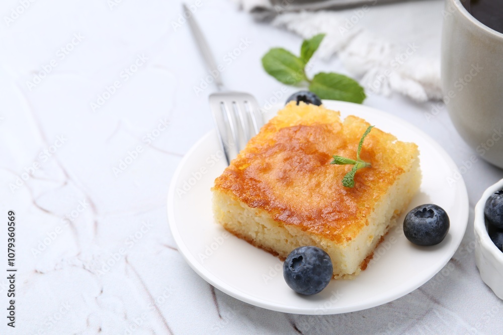 Slice of tasty semolina cake served on white textured table, closeup. Space for text Slice of tasty semolina cake served on white textured table, closeup. Space for text
