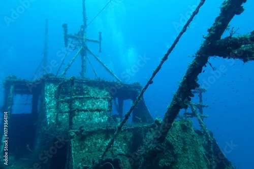 Bubbles from scuba diving on the deep boat wreck. Travel photo, seascape and wreck. Scuba diving trip, deep adventure wreck exploration. Deep blue ocean with the rusty metal shipwreck.