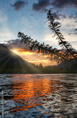 Morgengrauen mit Sonnenaufgang an einem Fluss mit wunderschöner Lichtspiegelung photo