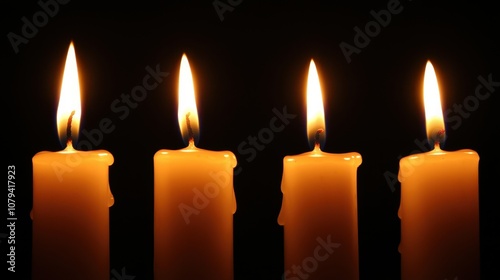 Four lit candles against black backdrop. A simple yet powerful image for concepts like hope, remembrance, or spirituality.