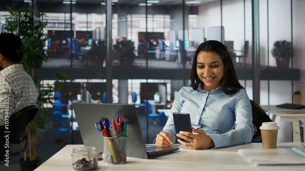 Fototapeta premium Indian employee engages in an online meeting with her team, discussing project briefs and upcoming deadlines. Using video call to ensure seamless communication and time management. Camera A.
