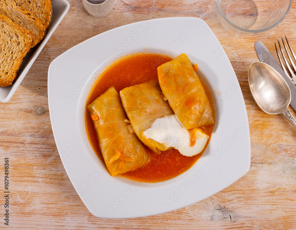Just cooked portion of russian cabbage rolls served with smetana (sour cream). Just cooked portion of russian cabbage rolls served with smetana (sour cream).