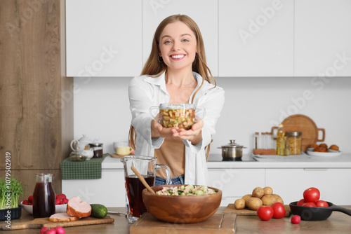 Young woman with okroshka in kitchen photo