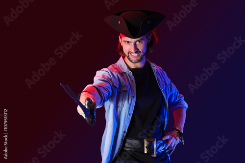 Young pirate with sword on dark background photo