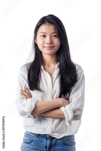 Woman with long hair is wearing a white shirt and blue jeans. She is smiling and has her arms crossed