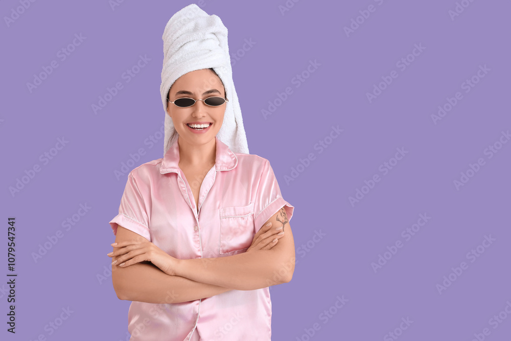 Young woman in pink pajamas with sunglasses after shower on lilac background Young woman in pink pajamas with sunglasses after shower on lilac background