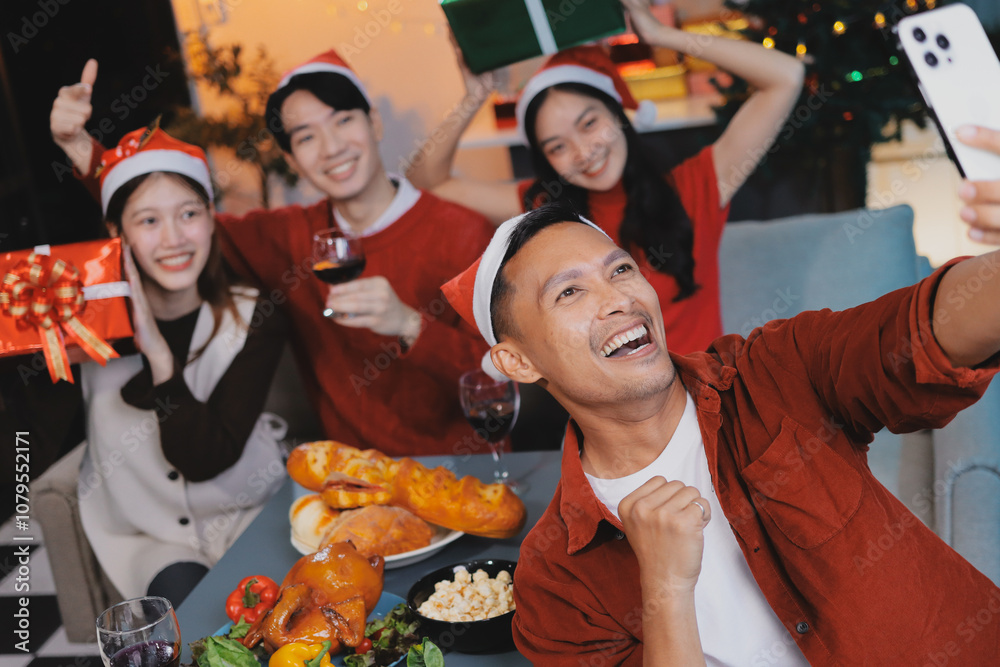 Group of young Asian man and women as friends having fun at a New Year's celebration, holding gift boxes standing by Christmas tree decoration, midnight countdown Party at home with holiday season. Group of young Asian man and women as friends having fun at a New Year's celebration, holding gift boxes standing by Christmas tree decoration, midnight countdown Party at home with holiday season.