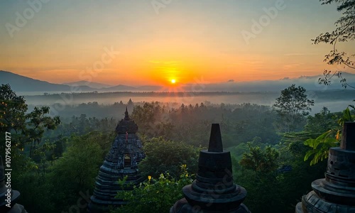 Ancient Stone Structures Silhouetted Against a Sunrise Over Foggy Mountains