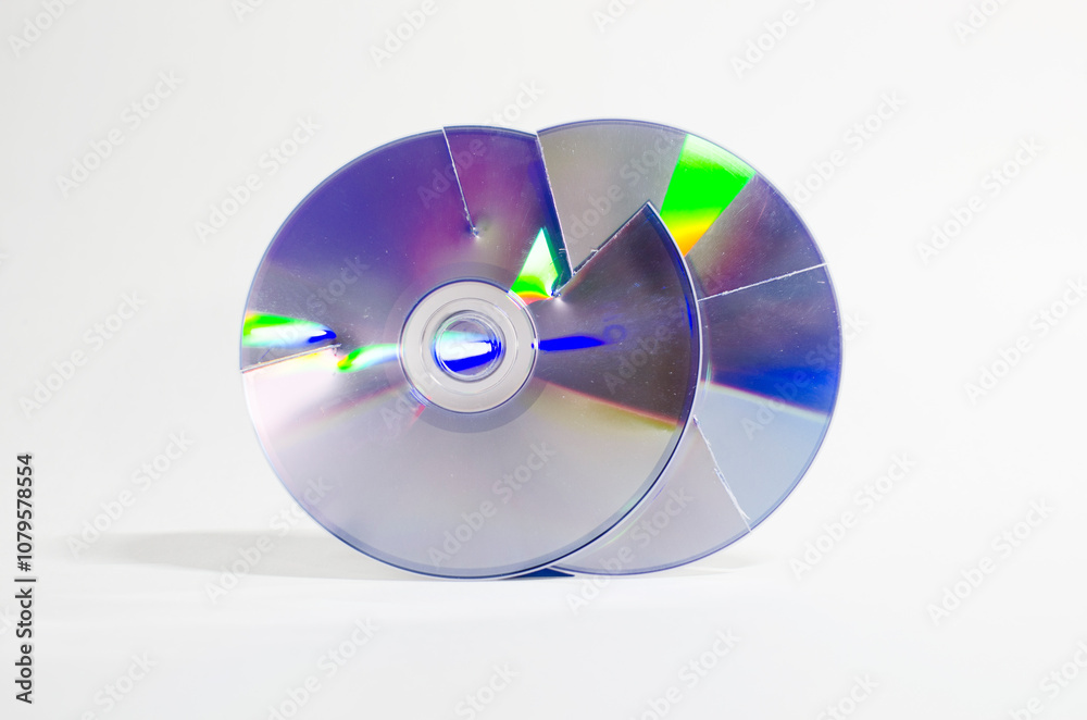Two cut cd roms next to each other in vertical position, representing the concept of data protection and recycling. Two cut cd roms next to each other in vertical position, representing the concept of data protection and recycling.