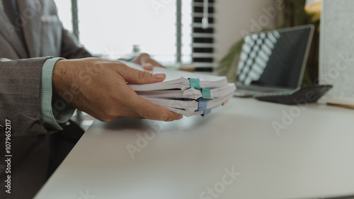 Fotografie An office worker is putting important documents together to keep everything safe
