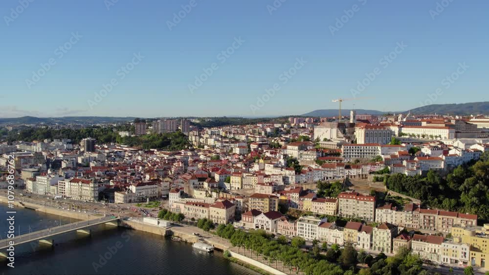 Coimbra cityscape under blue sky, historic architecture along the Mondego River - aerial Coimbra cityscape under blue sky, historic architecture along the Mondego River - aerial