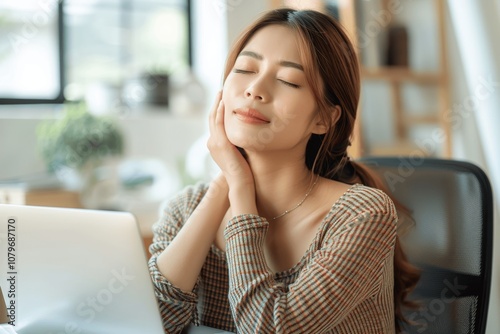 Asian woman suffering neck pain while working on laptop at home, healthcare concept with provider support