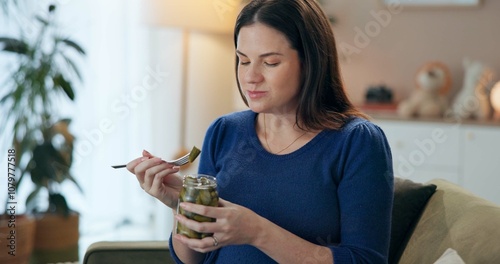 Home, pregnant woman and relax with pickle for eating, nutrition or wellness for baby development. Sofa, female person or hungry with vegetable for pregnancy, craving or fermented snack for vitamin k