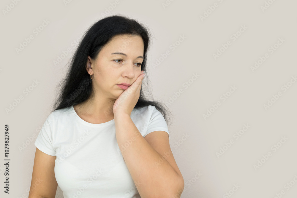 Beautiful young woman suffering from toothache on gray background Beautiful young woman suffering from toothache on gray background